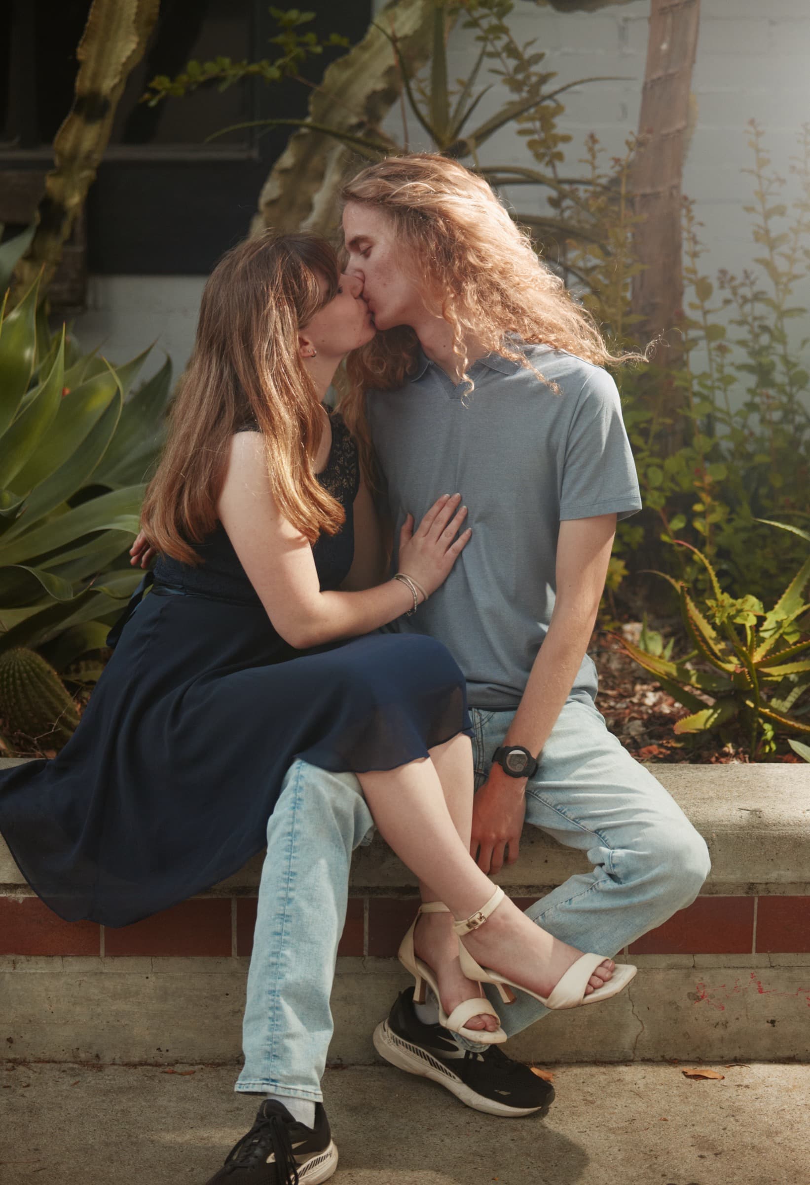 Couple kissing on a stone wall