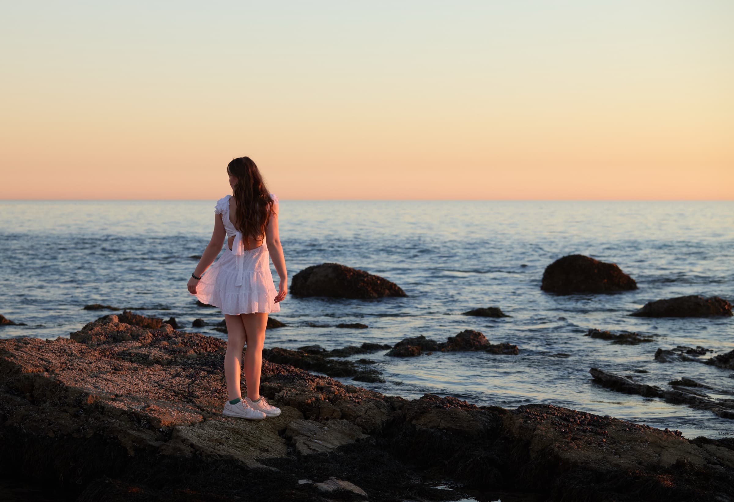 Subject on the rocks, sunset over the Pacific